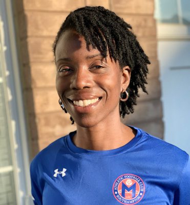 IMG_4403 A woman with dreadlocks wearing blue shirt and smiling.