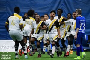 A jubilant rugby team celebrating on the field.