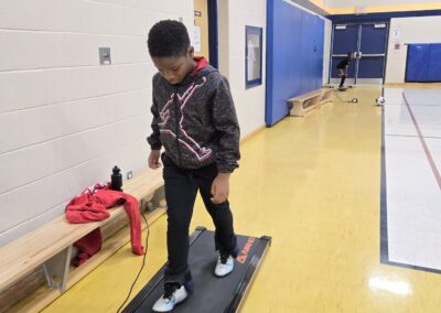 A young boy stepping onto a platform in a gymnasium.