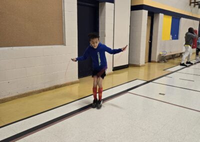 Child balancing on a gymnasium line, arms outstretched for stability.