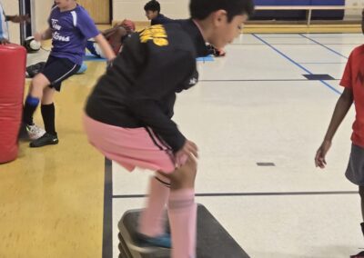 A boy jumps onto a step platform during a gym activity.