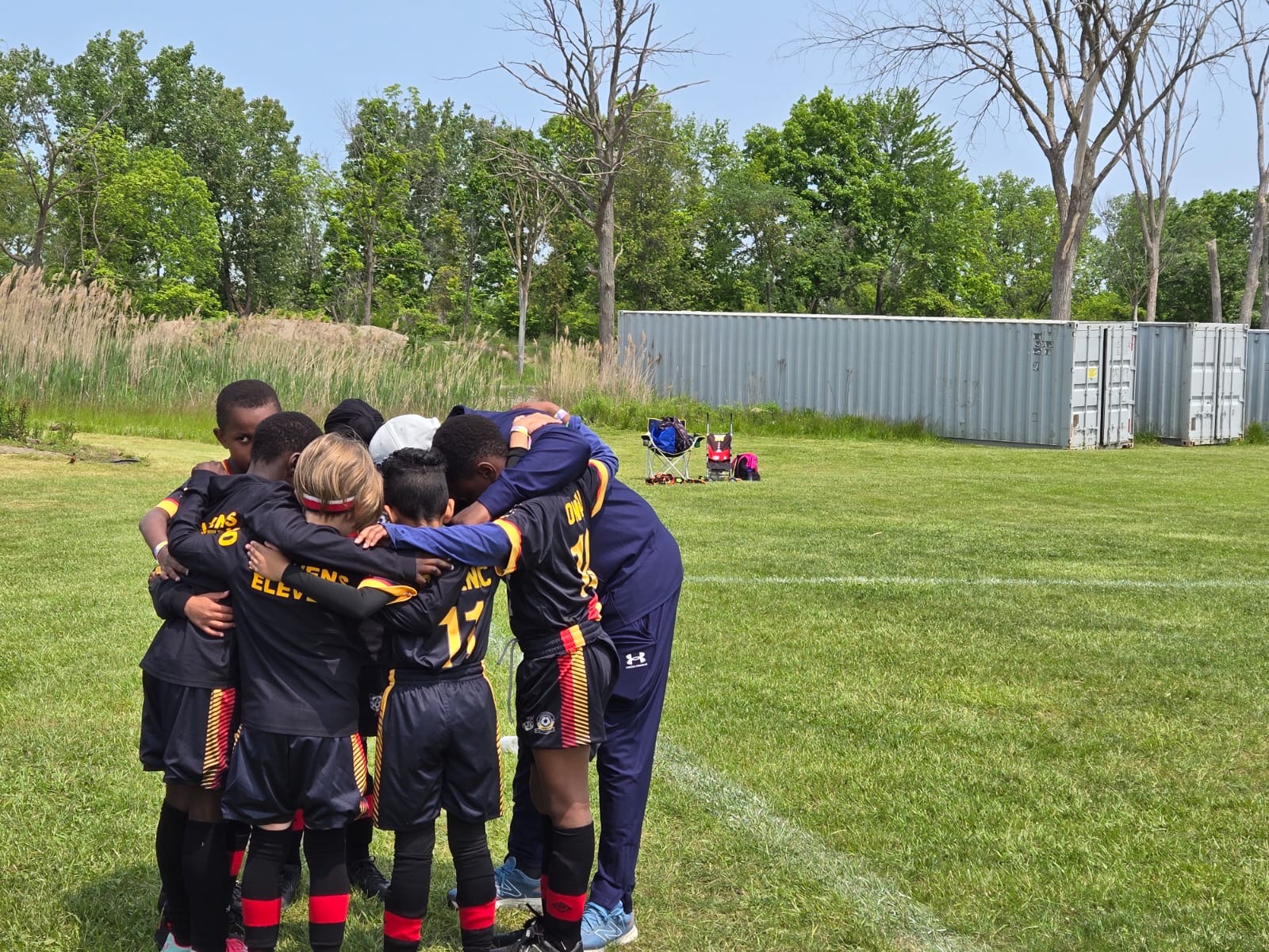 Youth flag football players competing indoors on turf field.