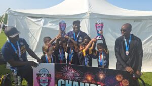 Team of kids celebrating a championship win, holding trophies and medals.