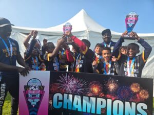 Celebration of champions holding trophies and medals on stage.