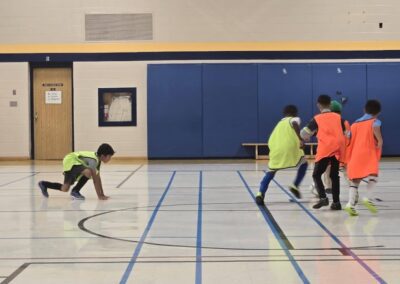 Children playing indoor soccer in a gymnasium.