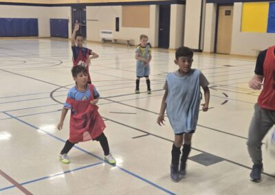 Children playing basketball in a gymnasium.