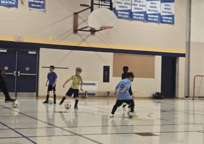 Kids playing basketball in a gymnasium.