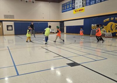 Group of people playing indoor basketball in a gymnasium.