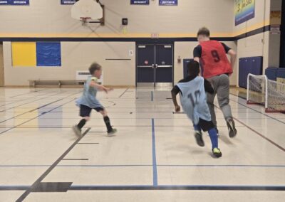 Kids playing basketball in a gymnasium, focused on the game.