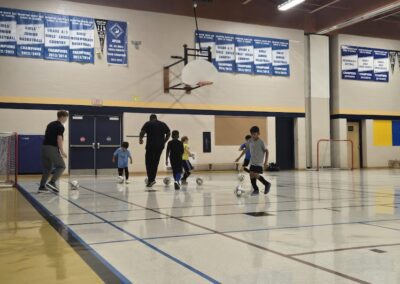 Kids playing basketball in a gymnasium.