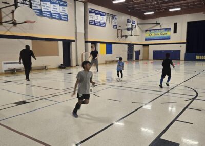Children playing and running in a school gymnasium.