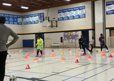 Children navigate an obstacle course in a school gymnasium.
