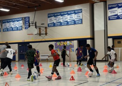 Group training in a gym using cones and soccer balls.