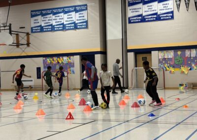 People participating in an indoor sports activity with cones and balls.