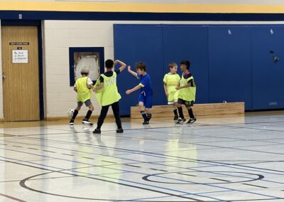 Children playing basketball indoors, focusing on the game.