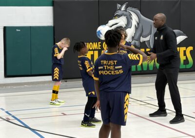 Young basketball players practicing a drill in a gym.
