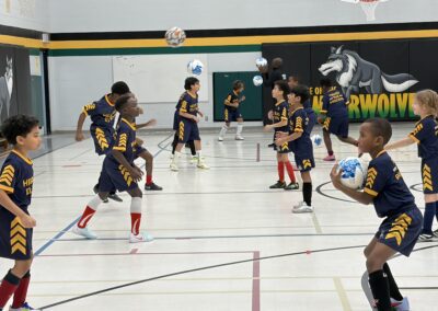 Youth basketball players practicing dribbling on an indoor court.