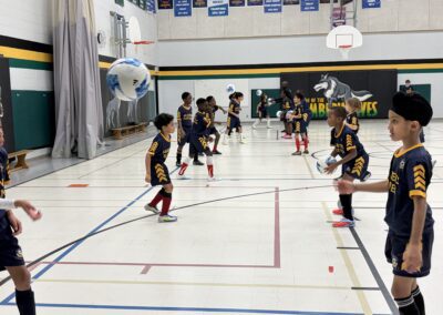 Kids practicing basketball drills in a gym.