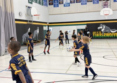 Youth basketball players practicing passing drills in a gym.