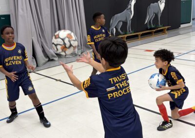 Children playing volleyball indoors during practice.