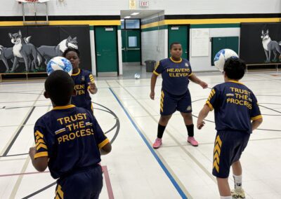Young basketball players practicing teamwork and skills indoors.