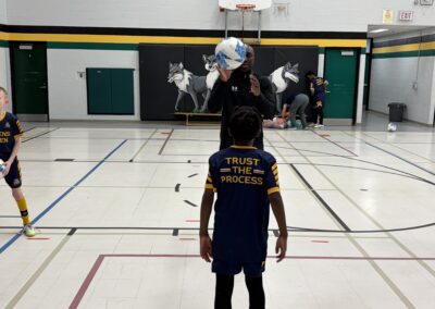 Child wearing a mask and navy outfit in a gymnasium.
