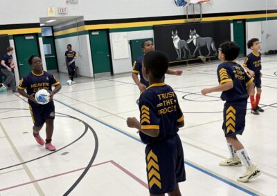 Kids playing basketball in a gym during practice.