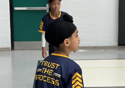 Boy wearing a 'Trust the Process' sports jersey and turban indoors.
