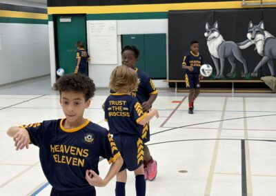 Young basketball players in yellow and blue uniforms on a gym court.