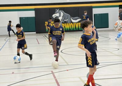 Youth basketball players in action during a game on an indoor court.