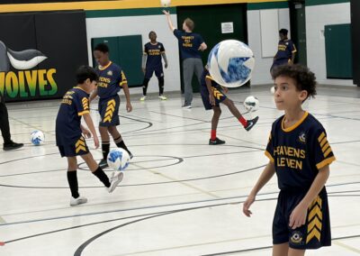 Youth basketball players practicing dribbling drills in a gym.