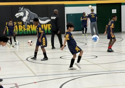 Young basketball players practicing on an indoor court.