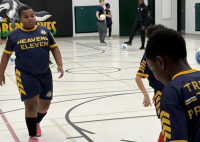 Youth basketball players practicing on an indoor court.