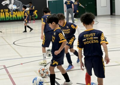 Young boys playing indoor soccer, focused on the ball.