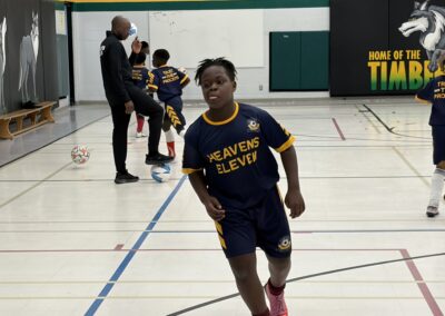 A young basketball player dribbling on an indoor court.