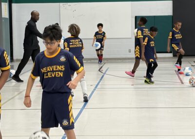 Young boys playing indoor basketball in matching uniforms.