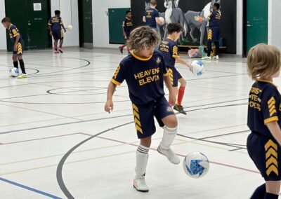 Young soccer player controlling the ball indoors.