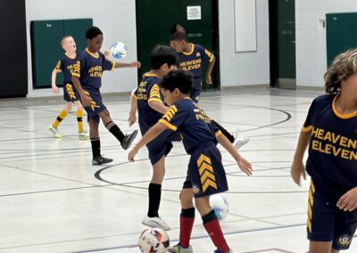 Youth soccer players actively playing indoors during a match.