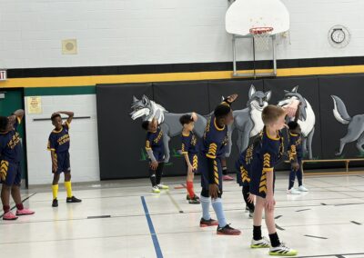 Youth basketball players with wolf masks practicing in a gym.