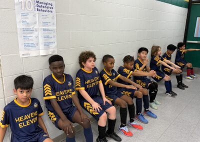 Youth soccer team sitting on a bench.