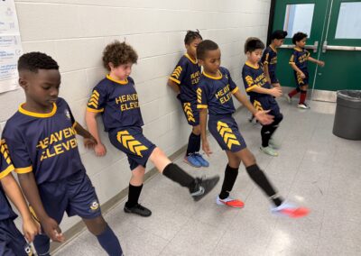 Young boys in matching sports uniforms practicing kicking.