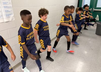 Children in sports uniforms warming up indoors.