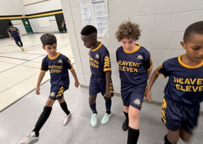 Young soccer players in matching uniforms walking together on a field.