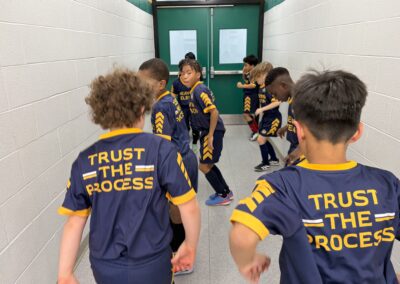 Kids warming up in matching sports jerseys that say 'Trust the Process.'