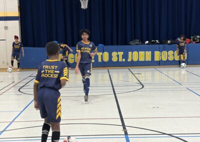 Two girls playing basketball in a gymnasium during a game.
