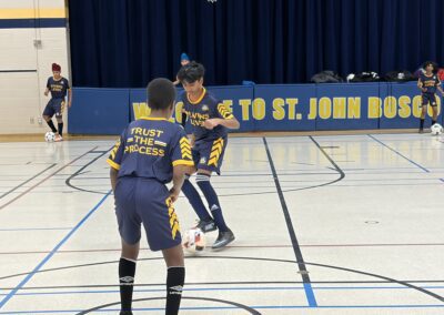 Two young basketball players practicing passing in a gym.