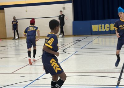 Youth basketball players in blue and yellow uniforms on a gym court.