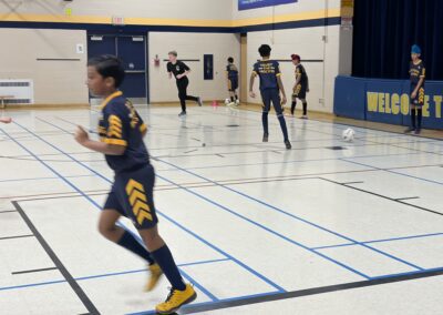 Young athletes practicing basketball drills in a gymnasium.