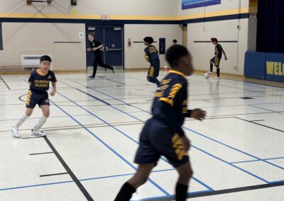 Young boys playing basketball in a gymnasium.