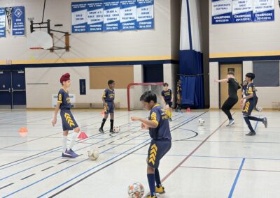 Young basketball players practice in a gymnasium during a game.